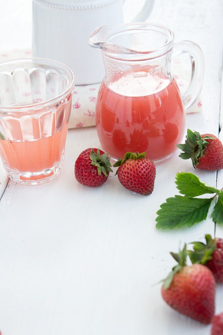 Selbstgemachter Erdbeersirup und frische Erdbeeren
