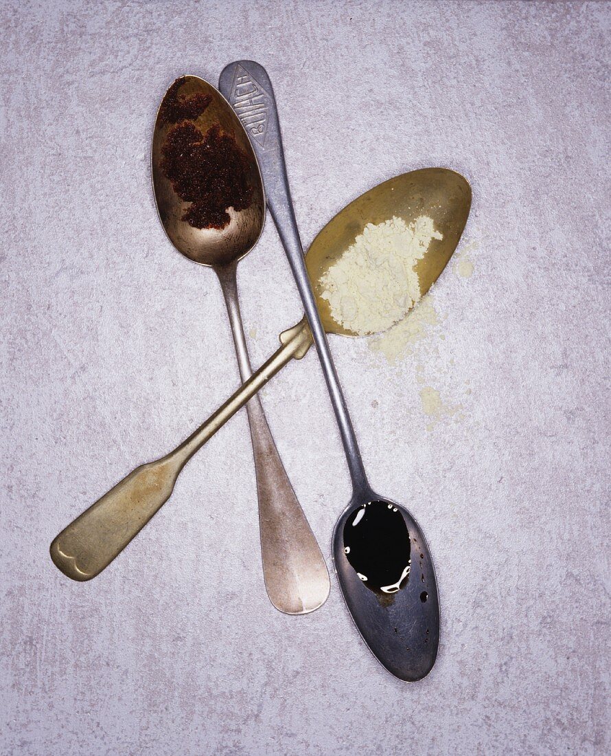 Old silver spoons on a white surface