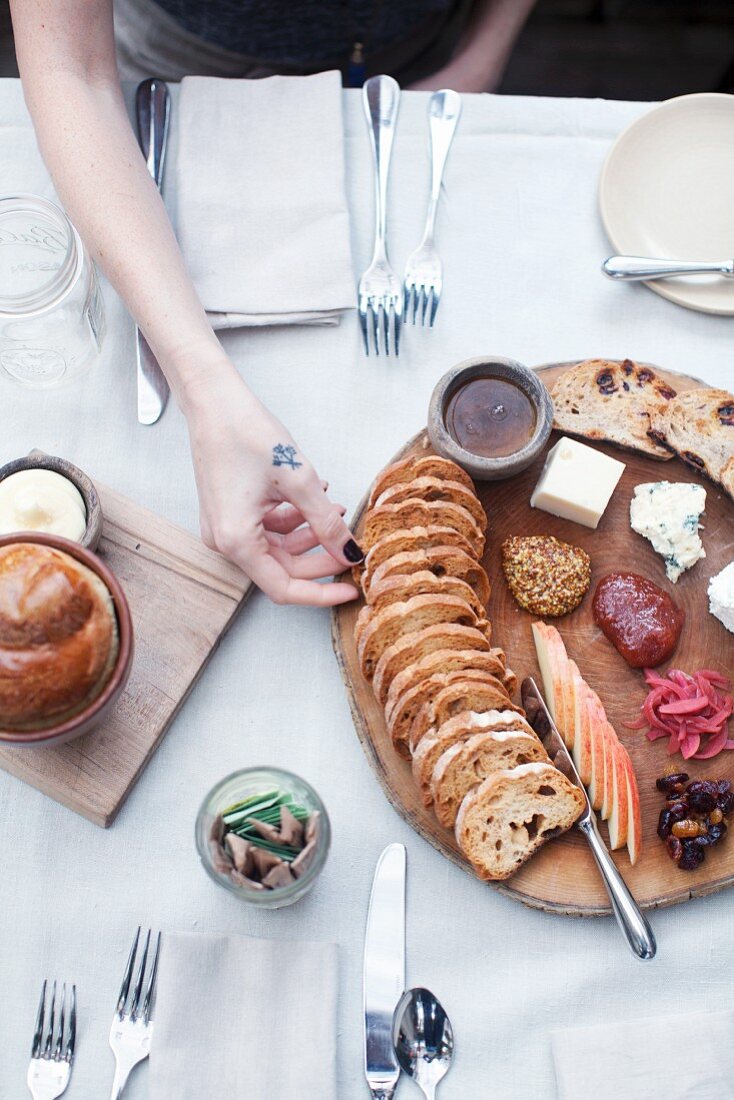 A cheese platter with a rustic baguette