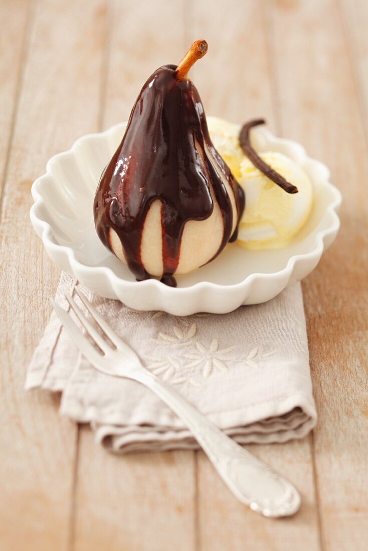 Poached Pear with Chocolate Sauce and a Scoop of Vanilla Ice Cream, Spoon