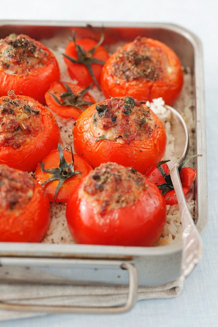 Baked tomatoes with sausage filling in a roasting tin