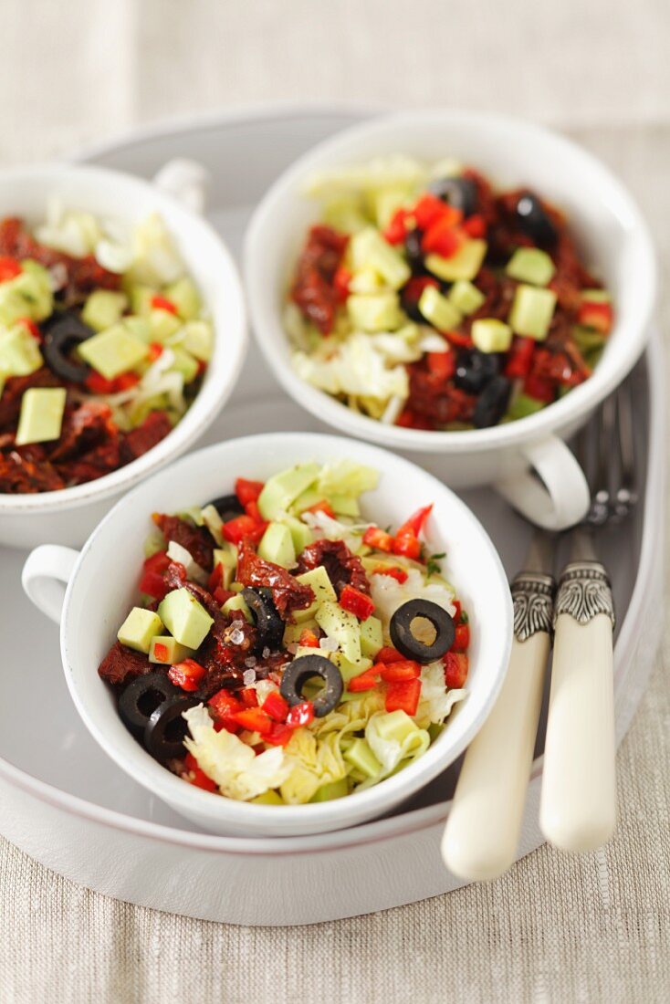 Eissalat mit Avocado, schwarze Oliven, Paprika und getrockneten Tomaten