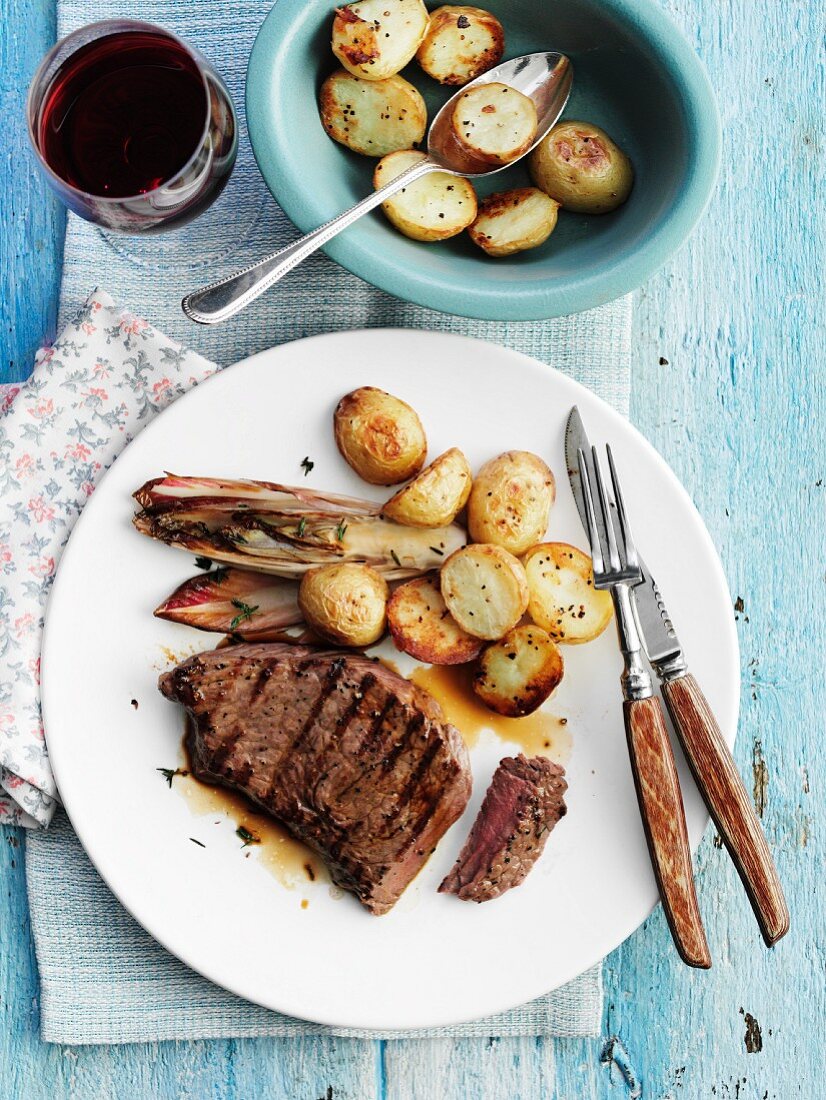 Grilled beef steak with endive and potatoes
