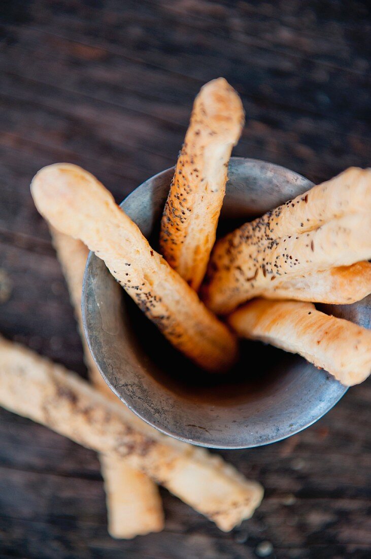 Poppy seed breadsticks in a metal container (view from above)