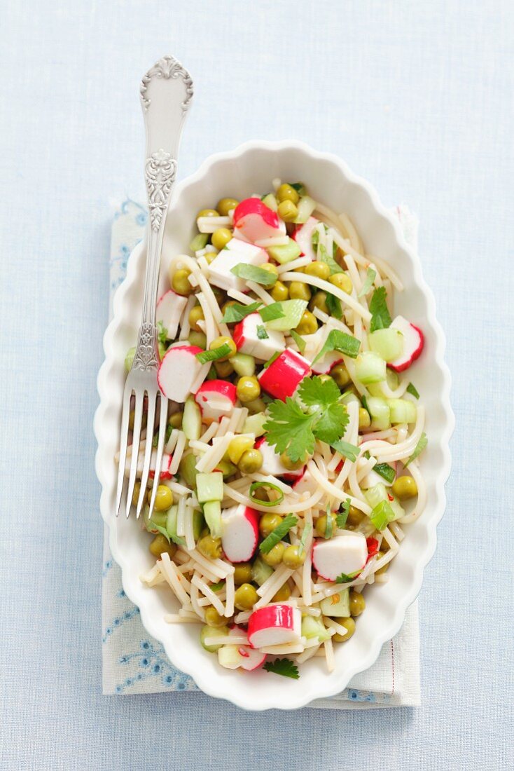 Noodle salad with surimi, cucumber, peas and coriander