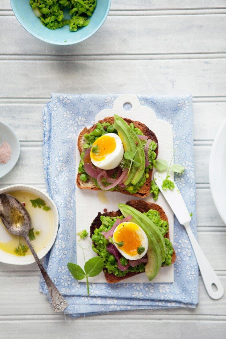 Toast mit Erbsenpüree, eingelegten Zwiebeln und Ei