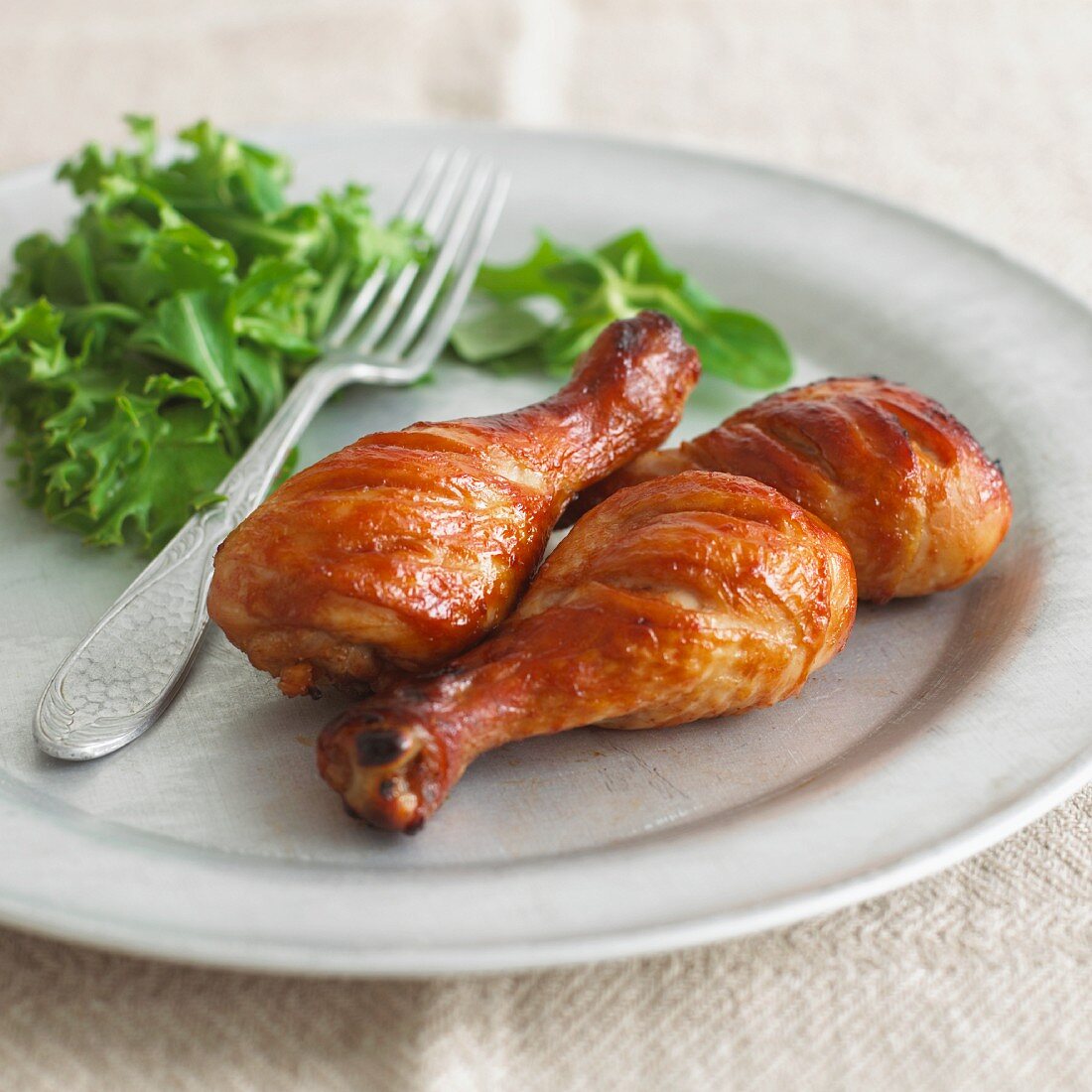 Glazed, grilled chicken legs with green salad
