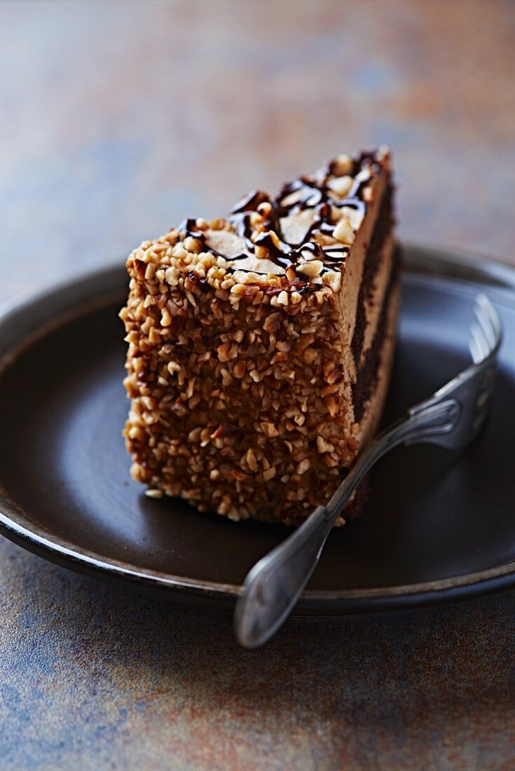 Ein Stück Nuss-Schokoladen-Kuchen auf Teller mit Gabel