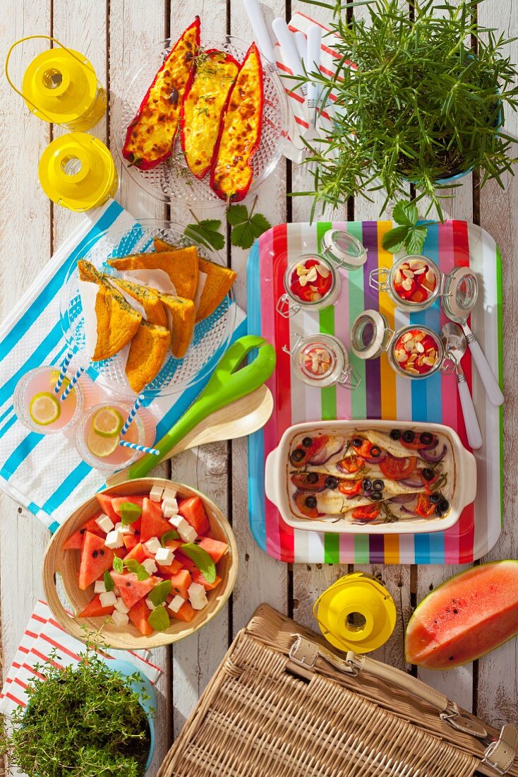 Summer picnic with stuffed peppers, spinach omelette, muesli, fish, lemonade and watermelon salad