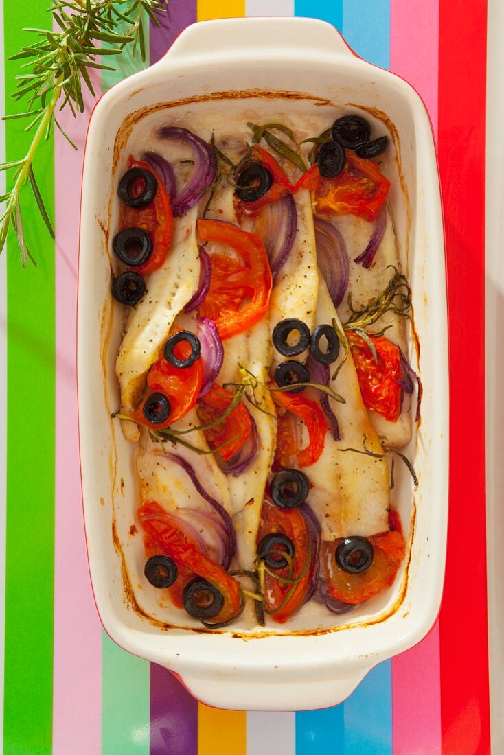 Gebratenes Fischfilet mit roten Zwiebeln, Tomaten, schwarzen Oliven und Rosmarin