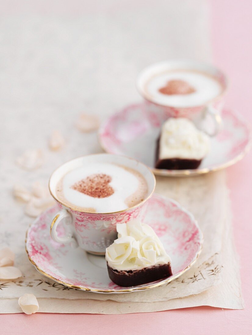 Petit Four und Cappuccino mit Kakaoherz