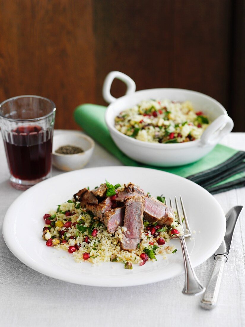 Lamb with harissa on couscous with pomegranate seeds