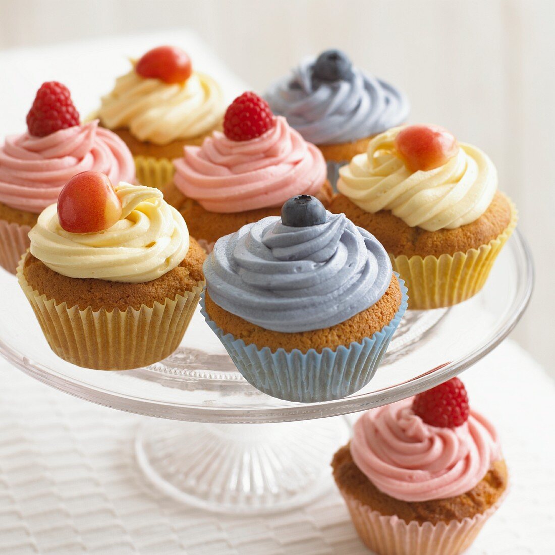 Cupcakes with raspberries and blueberries on a cake stand