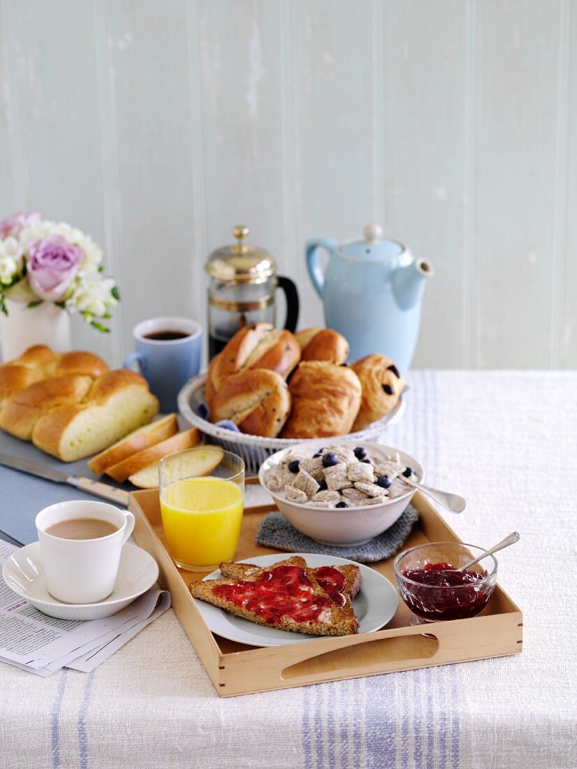Frühstückstablett mit Toast, Cerealien, Marmelade, Hefebrot, Kaffee und Tee