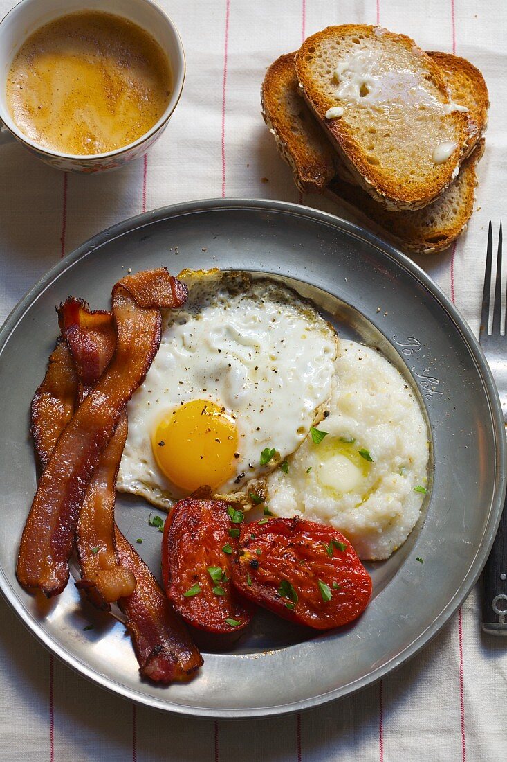 Deftiges Frühstück mit Eiern, Speck, Maisgrütze & Tomaten
