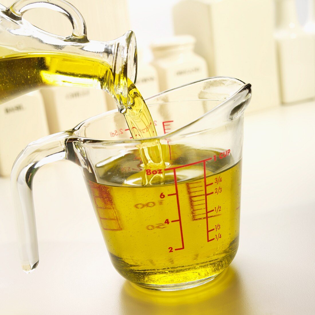 Olivenöl in einen Messbecher aus Glas gießen