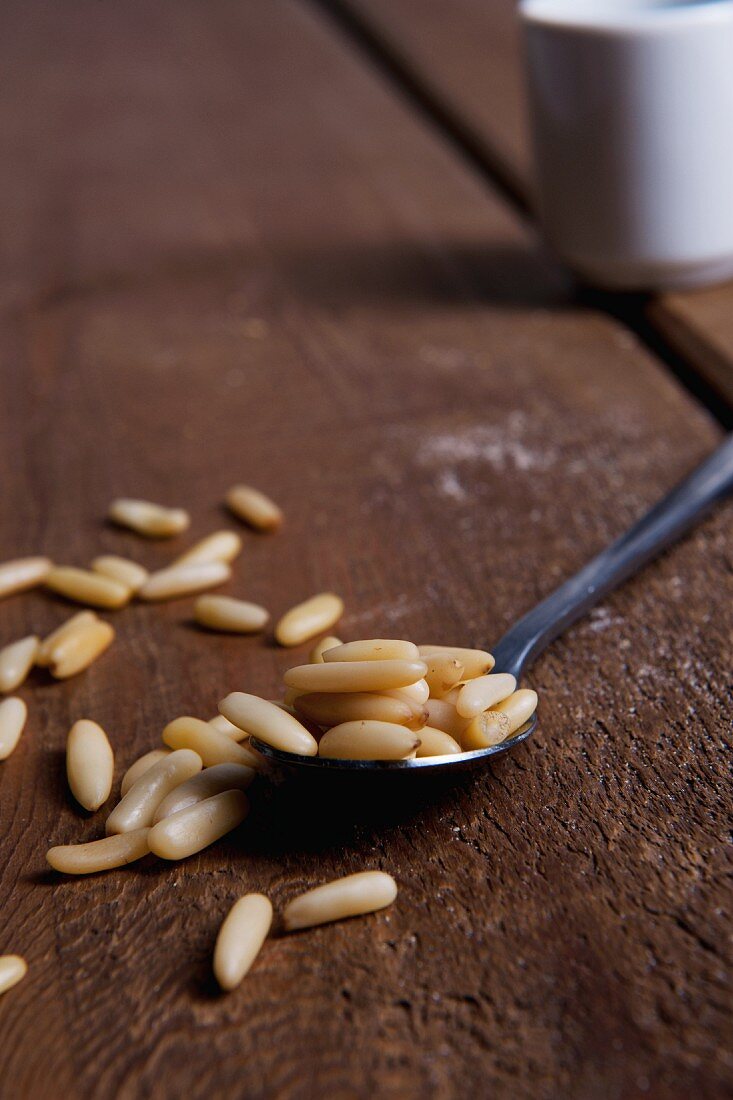 Pine seeds on a spoon and a wooden table