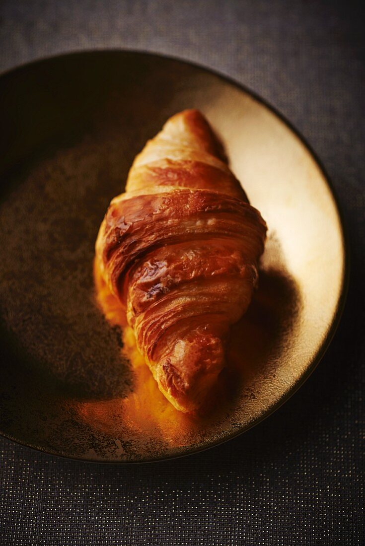 Croissant auf Goldteller