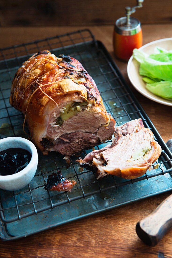 Roast pork with apples and sage, sliced, on a rack