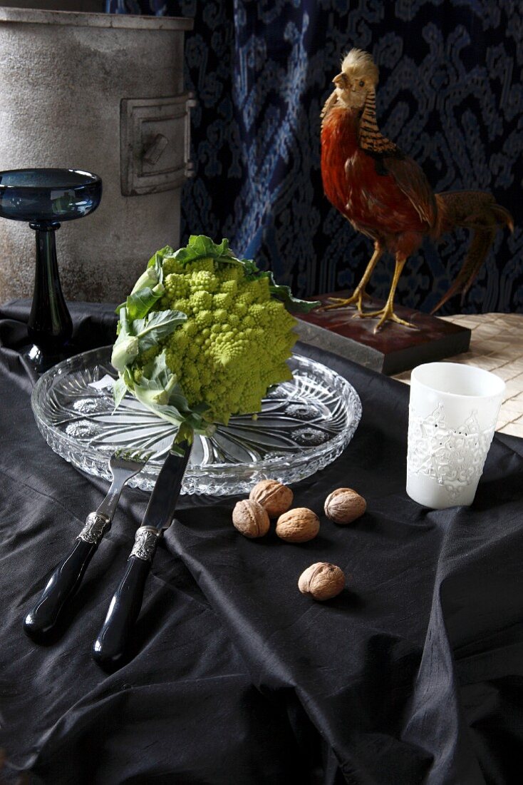 Romanesco cauliflower on crystal platter and black fabric in front of mounted pheasant