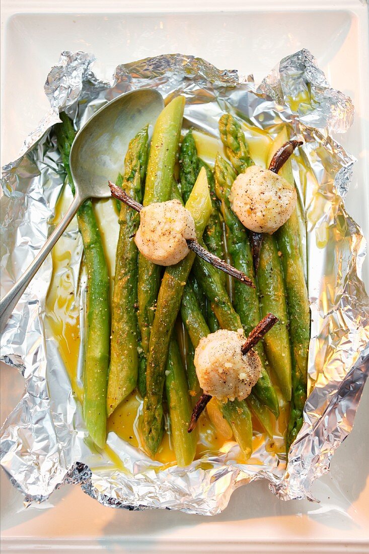 Green asparagus with scallops in aluminium foil