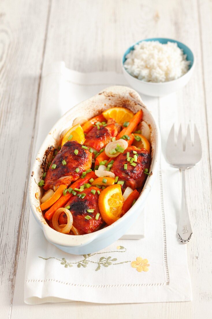 Oven-roasted chicken leg with carrots and oranges