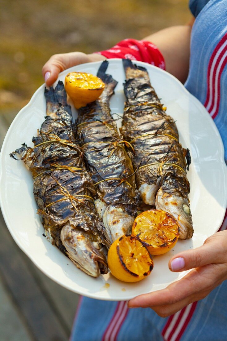 Grilled trout wrapped in vine leaves