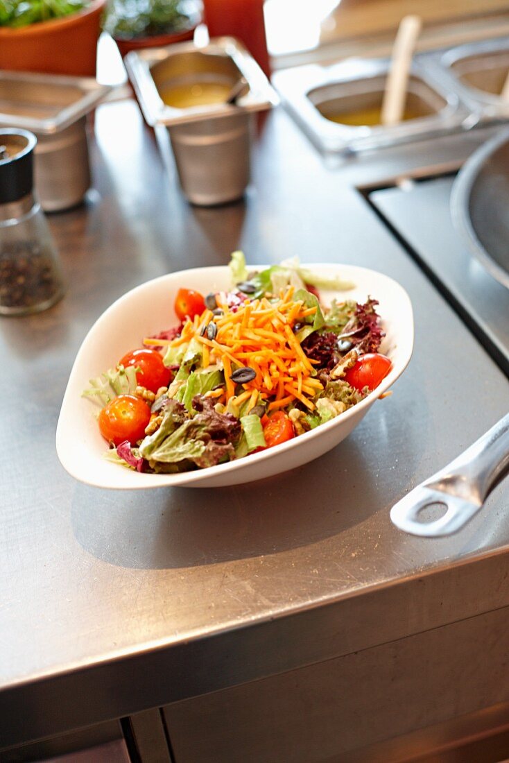 Blattsalat mit Möhren und Tomaten in der Restaurantküche