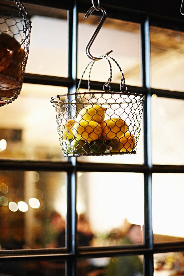 Lemons hanging in a wire basket in a restaurant