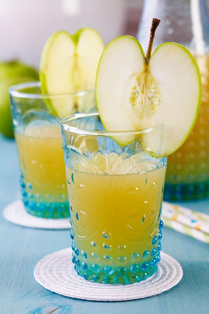 Glasses of apple juice decorated with slice of apple
