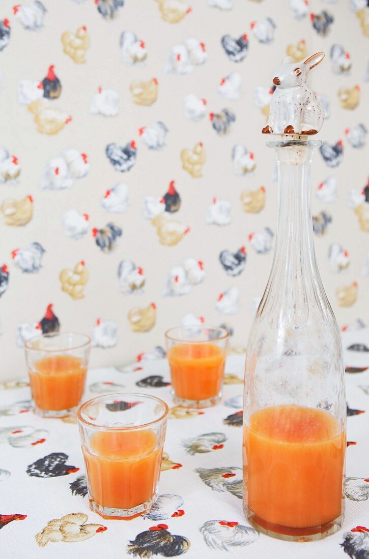 Hühnermotive auf Tischdecke und Tapete; Korken mit Hasenfigur auf einer Flasche mit Frühstücksgetränk