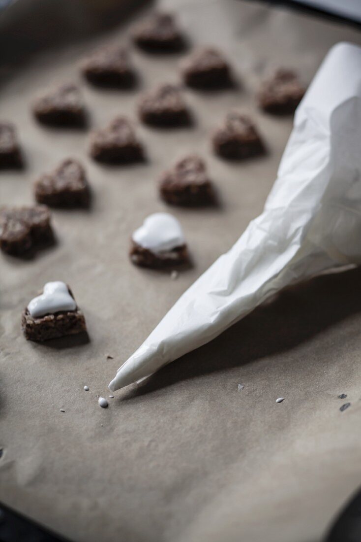 Zuckerguss wird auf Zimtherzen gespritzt