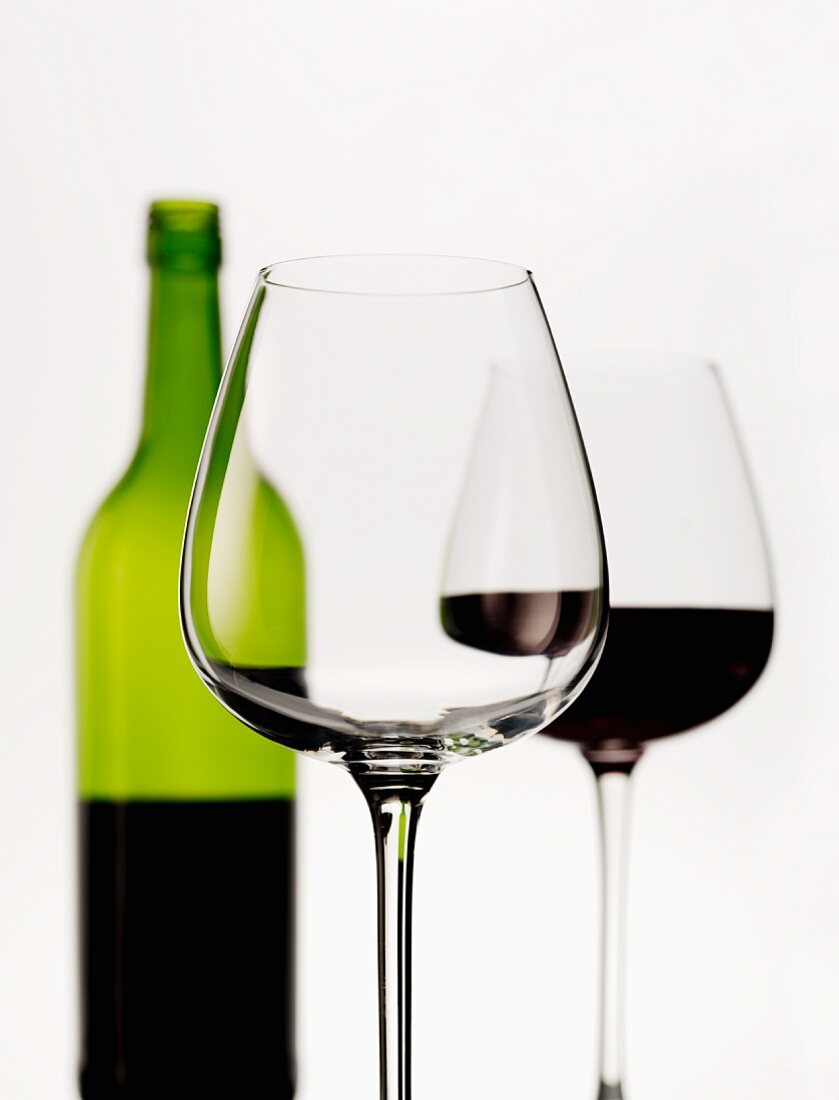 A still life featuring wine glasses and a bottle of red wine