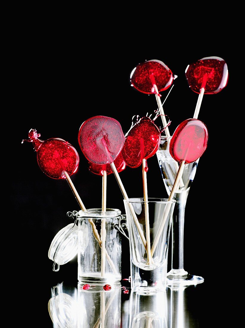 Red lollipops in assorted glass containers