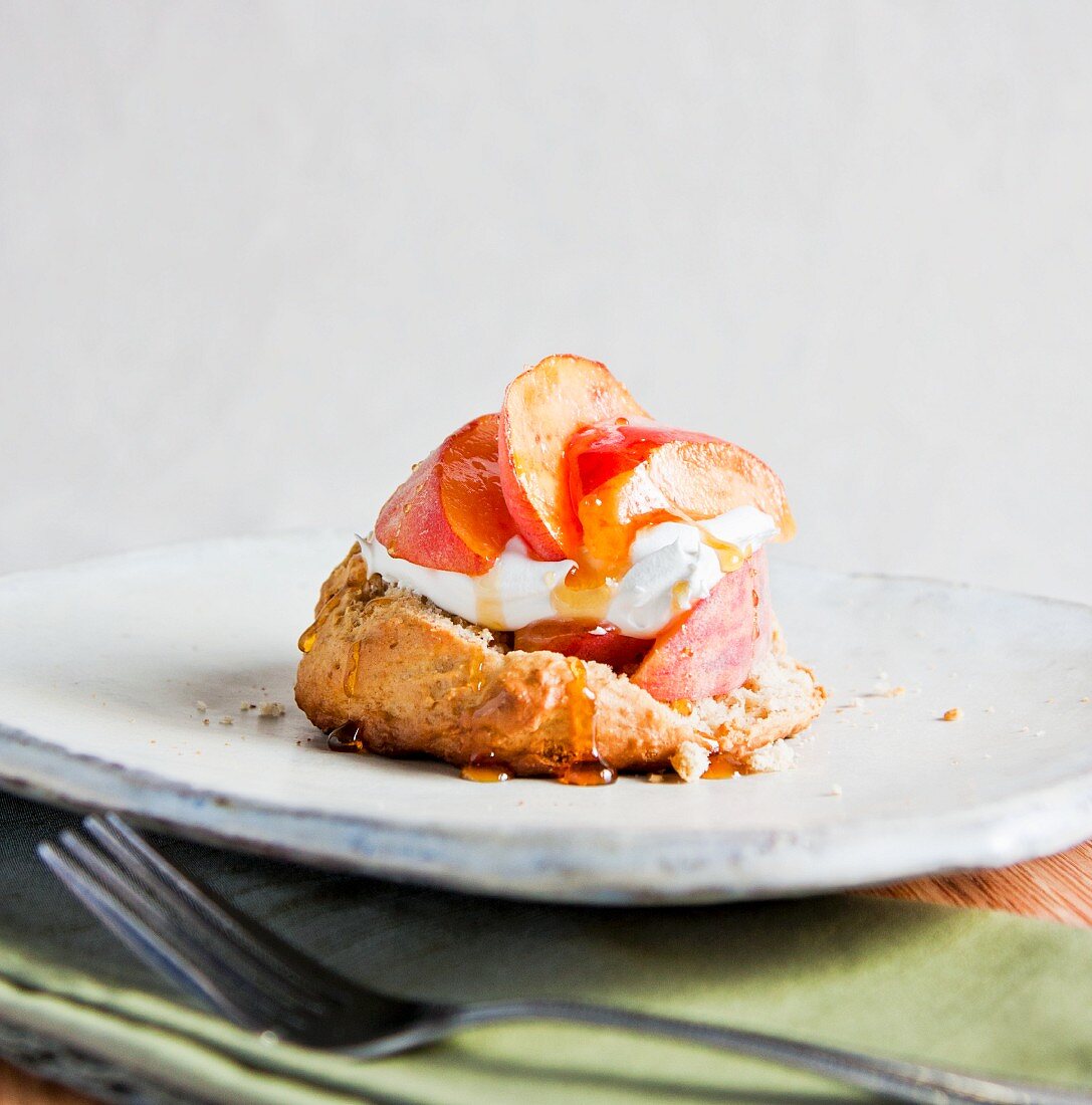 A Dessert of Fresh Peaches over a Homemade Biscuit with Whipped Cream and Drizzled with Honey