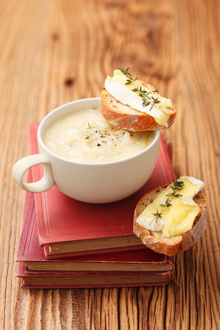 Creamy onion soup served with baguette topped with Camembert