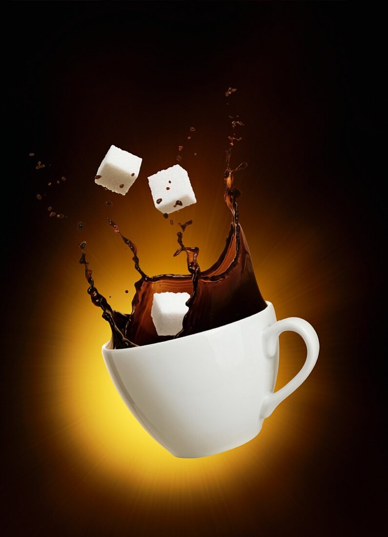 A splash of coffee with sugar cubes