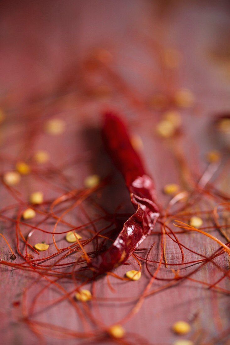 A dried chilli, chilli strands and chilli seeds