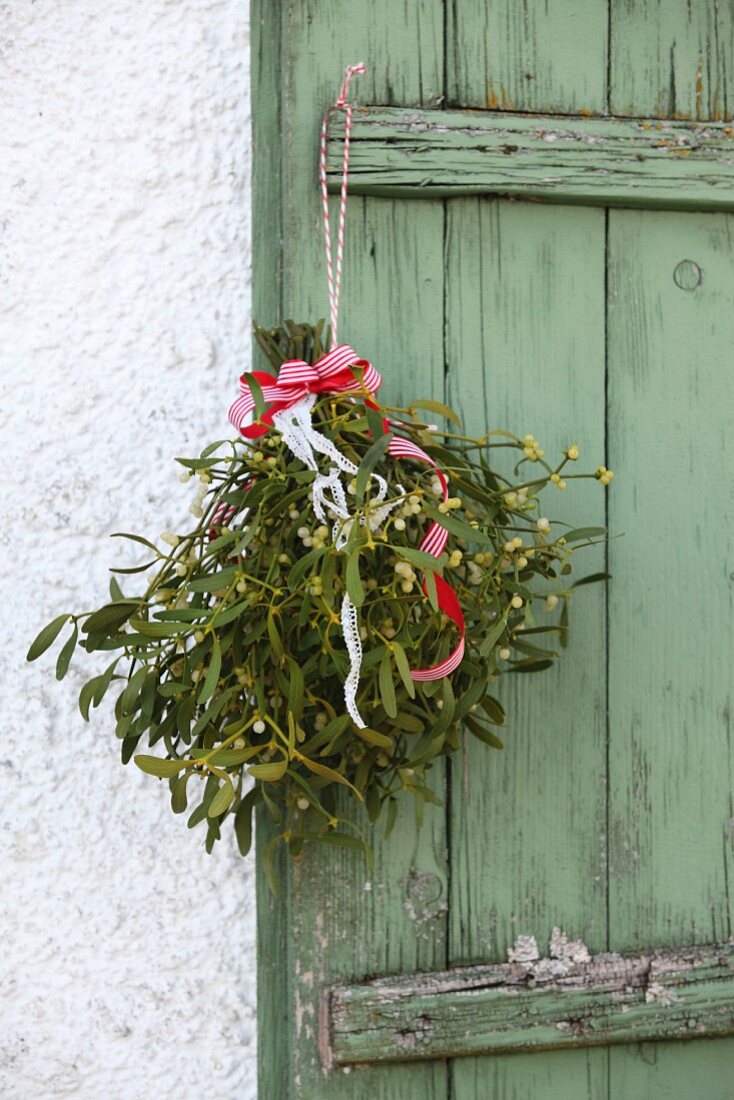 Bunch of mistle toe hung on weathered green shutter