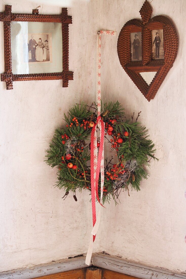 Wreath of pine branches and berries between vintage pictures