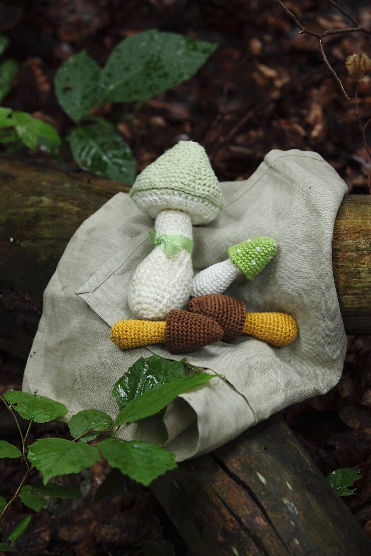 Gehäkelte Pilze auf Tuch im Wald