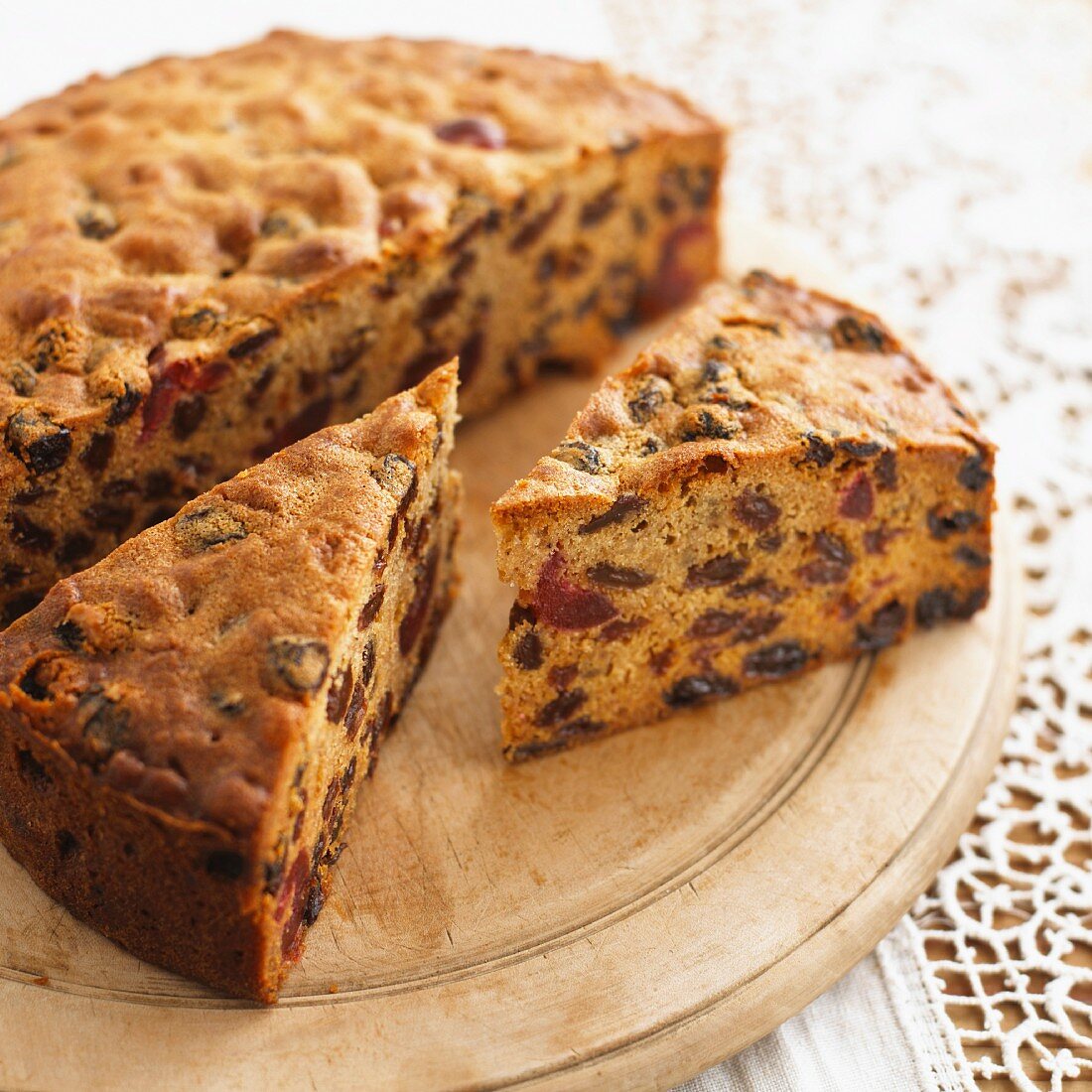 Fruitcake, partly sliced, on a wooden board