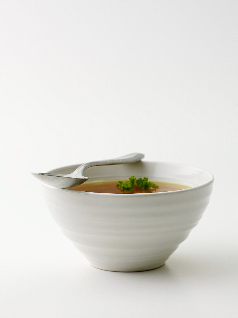 Clear broth with parsley in a soup bowl
