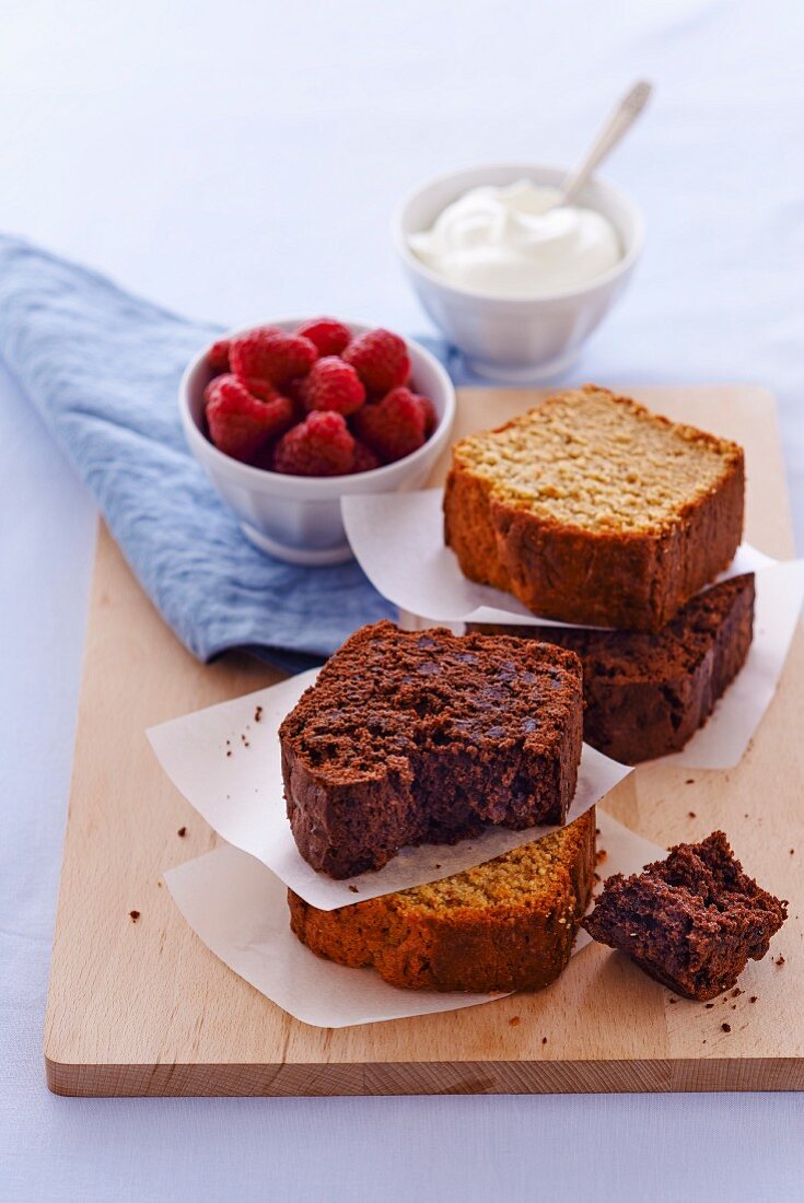 Einige Stücke Schokoladen- und Haselnusskuchen, Himbeeren und Sahne