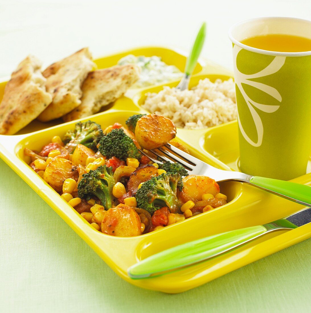 Currygemüse mit Reis & Getränk auf Kantinentablett