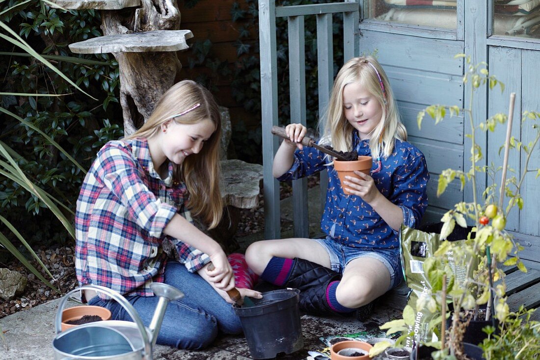 Two girl potting flower pots
