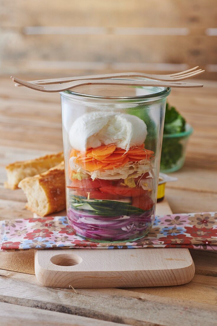 A layered salad with vegetables and mozzarella in a glass