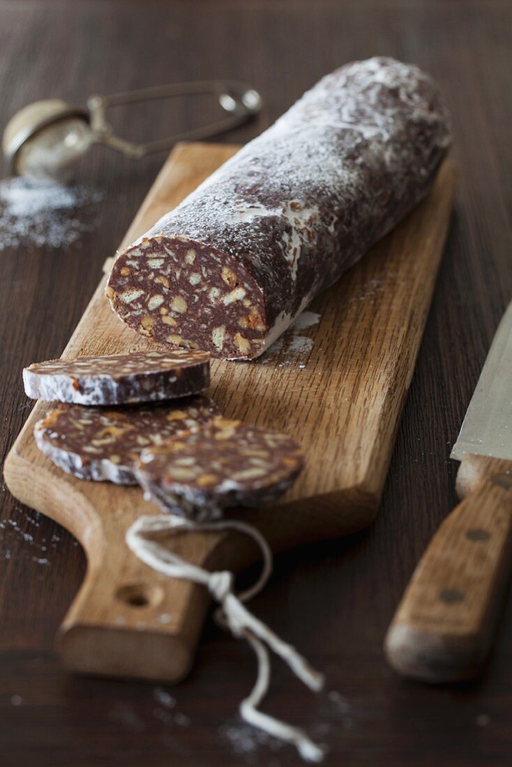 Chocolate Biscuit Salami with Walnuts and Rum (no bake) on cutting board