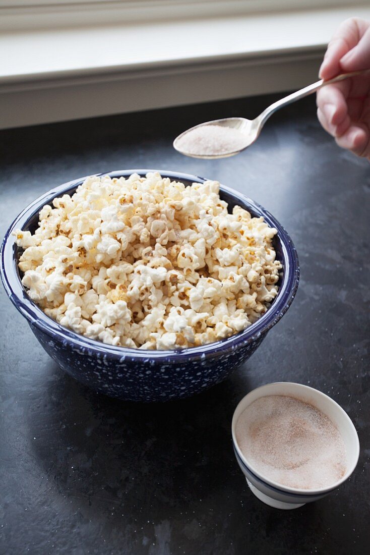 Home-made popcorn being sprinkled with sugar