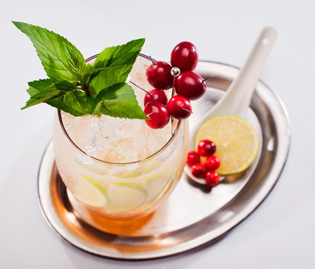 Fruchtcocktail mit Beeren und Minze auf Silbertablett